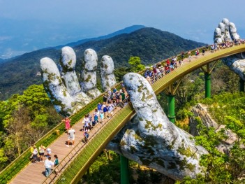 1_aerial_view_of_the_golden_bridge_is_lifted_by_two_giant_hands_in_the_tourist_resort_on_ba_na_hill_in_da_nang_vietnam